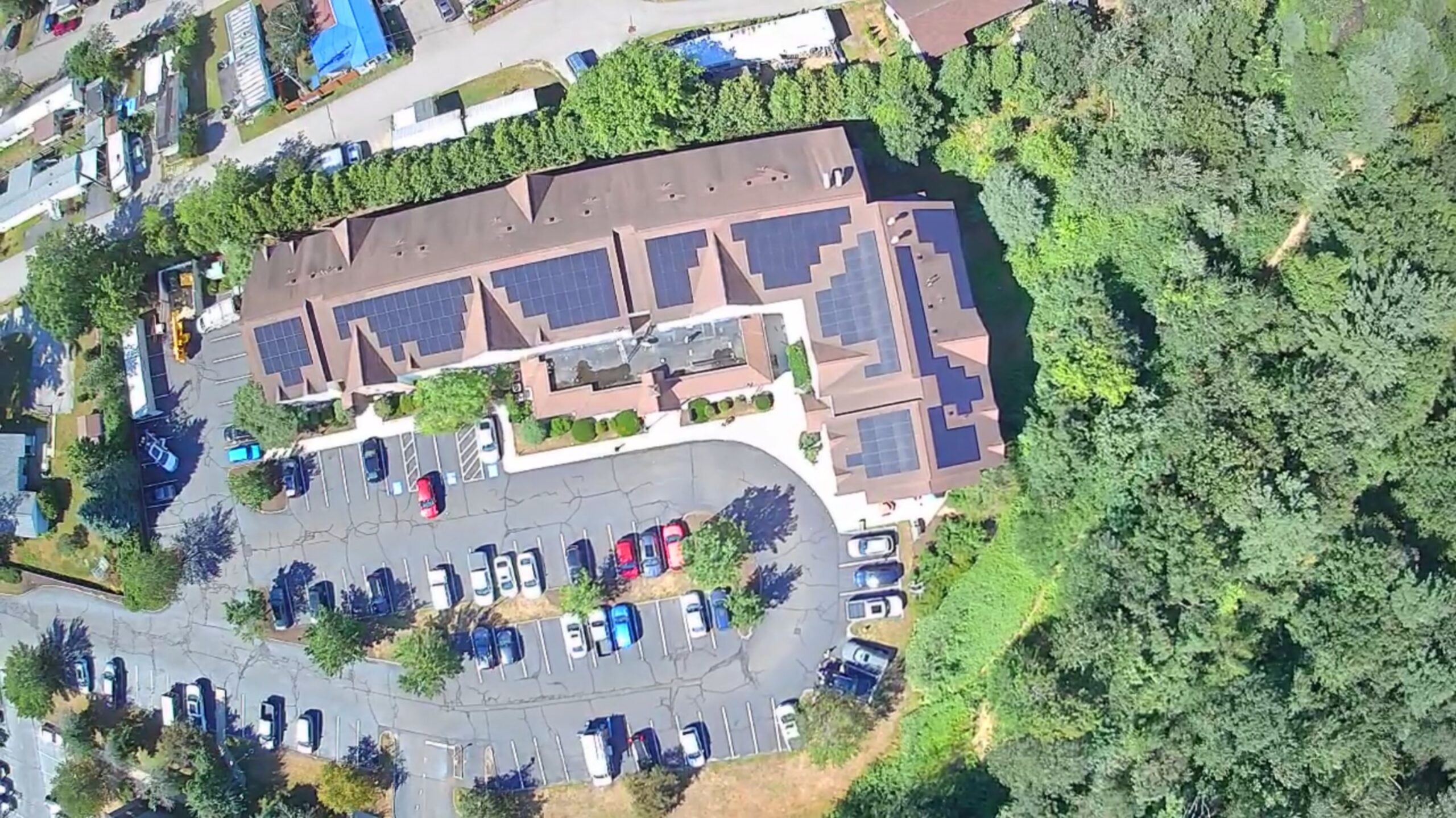 Aerial view of rooftop commercial solar installation at TownePlace Suites by Marriott in Manchester, NH, featuring multiple solar panel arrays installed by Porter Electrical Contracting.